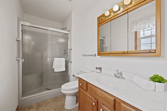 3440 Sunburst Ave, Marion, IA 52302 - full bathroom featuring vanity, tile patterned flooring, a stall shower, and toilet