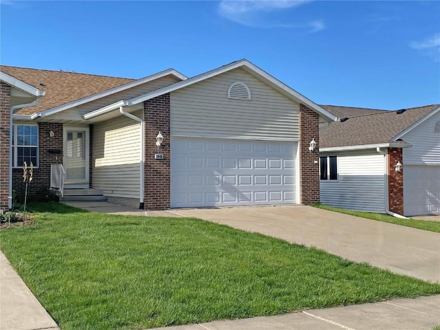 3440 Sunburst Ave, Marion, IA 52302 - view of front of property with an attached garage, concrete driveway, a front lawn, and brick siding