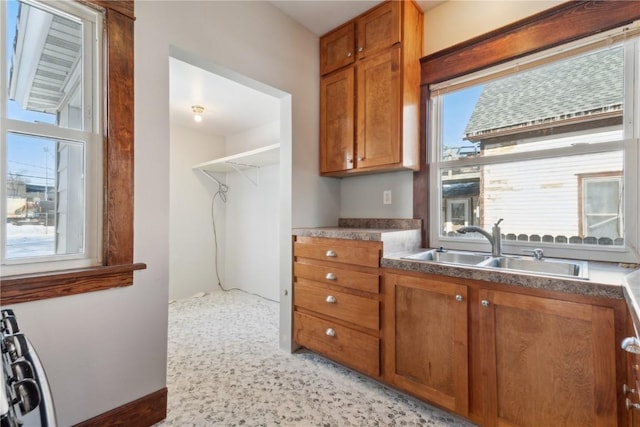 kitchen featuring dark countertops, a sink, and brown cabinets