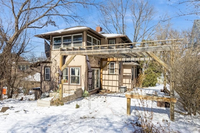 exterior space with a chimney, a pergola, and stucco siding