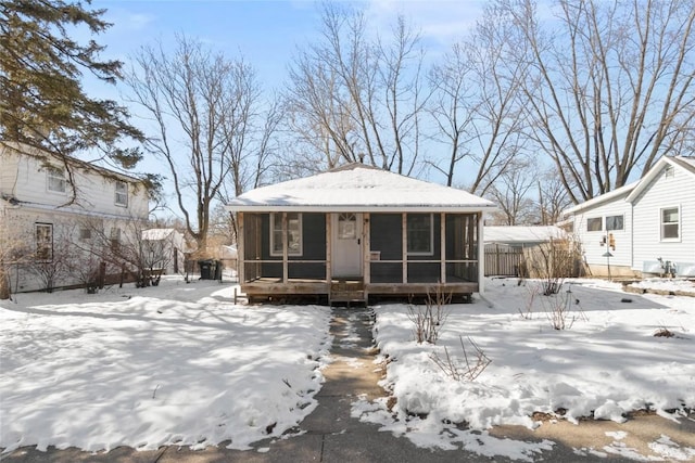 view of front of house featuring a sunroom and fence