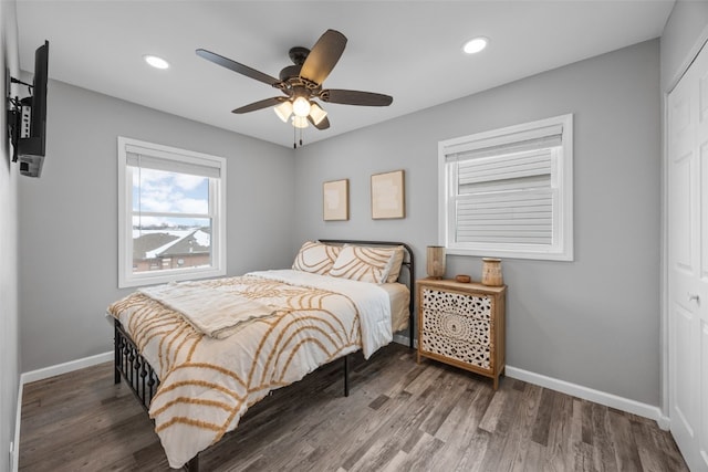 bedroom with dark wood-type flooring, recessed lighting, a closet, and baseboards