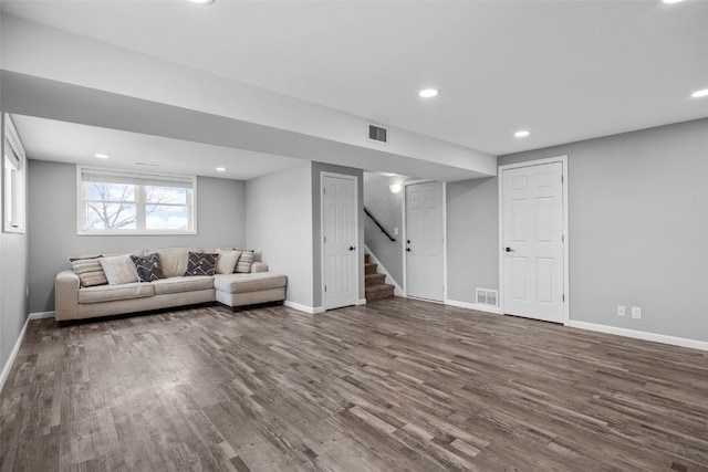 unfurnished living room featuring stairs, dark wood-type flooring, visible vents, and baseboards