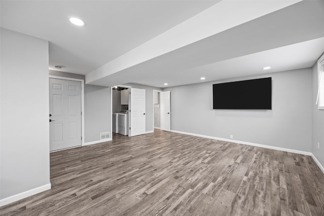 interior space with baseboards, washer / clothes dryer, wood finished floors, and recessed lighting