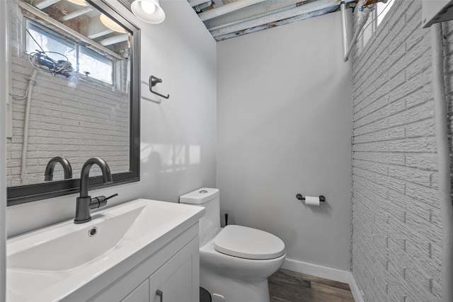 bathroom with vanity, wood finished floors, toilet, and baseboards