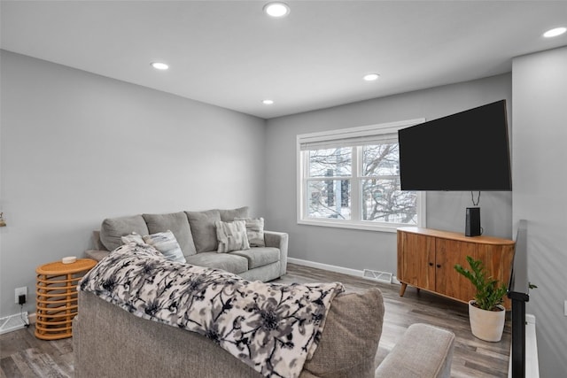 living area with recessed lighting, visible vents, baseboards, and wood finished floors