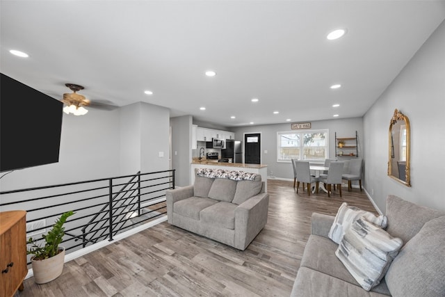 living area with recessed lighting, baseboards, and light wood finished floors