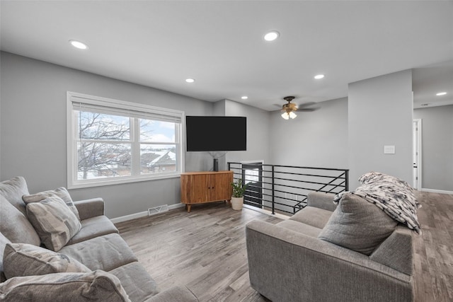 living area with light wood-style flooring, recessed lighting, visible vents, and baseboards