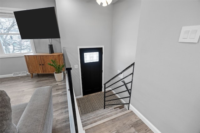 entryway featuring visible vents, baseboards, and wood finished floors