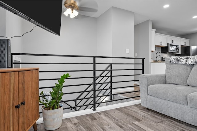 living area featuring an upstairs landing, light wood-style flooring, and recessed lighting