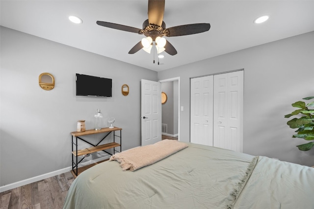 bedroom featuring a closet, recessed lighting, wood finished floors, and baseboards