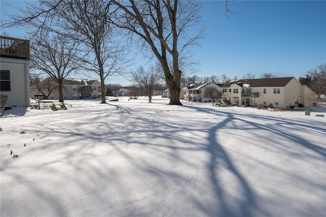 snowy yard featuring a residential view