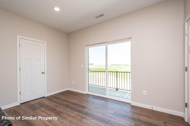 empty room featuring dark wood-type flooring, recessed lighting, visible vents, and baseboards