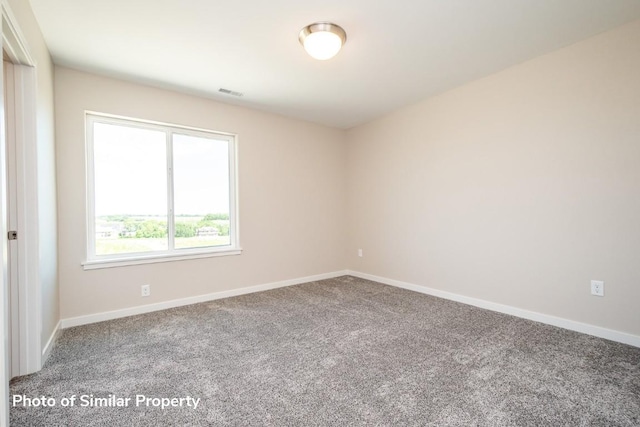 carpeted empty room featuring visible vents and baseboards