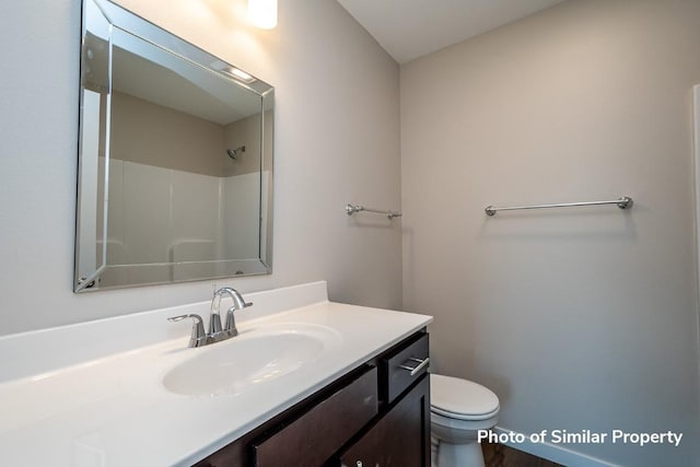 full bath with a shower, vanity, and toilet