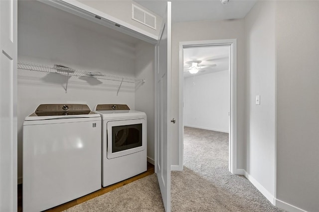 clothes washing area featuring laundry area, carpet floors, visible vents, baseboards, and washer and dryer