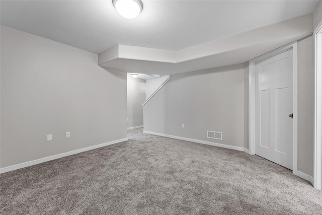 finished basement with carpet, visible vents, and baseboards