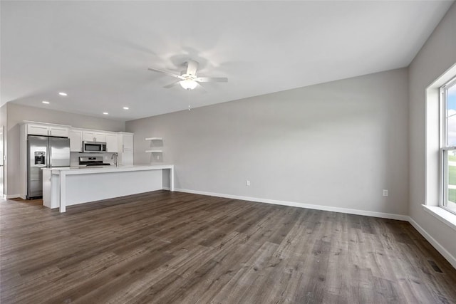 unfurnished living room with dark wood-style floors, recessed lighting, ceiling fan, and baseboards