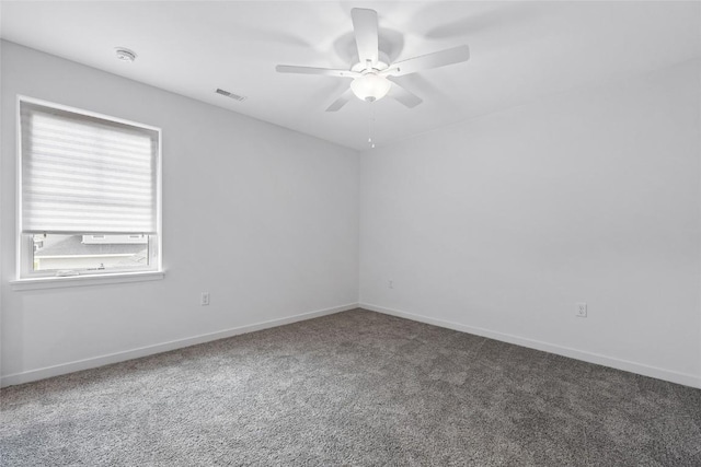 carpeted spare room with baseboards, visible vents, and a ceiling fan