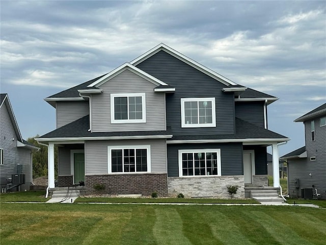 view of front facade with a front lawn and central air condition unit