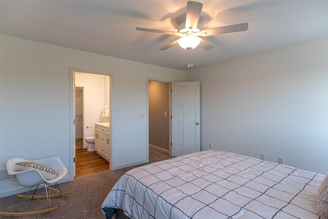 bedroom with light colored carpet, ceiling fan, baseboards, and ensuite bathroom