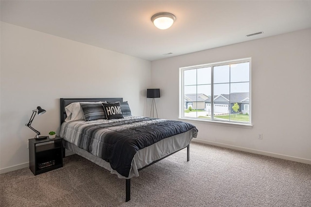 bedroom with carpet floors, visible vents, and baseboards