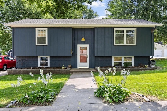 split foyer home featuring brick siding and a front yard