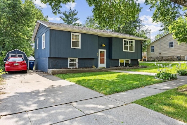 bi-level home with driveway, brick siding, and a front yard