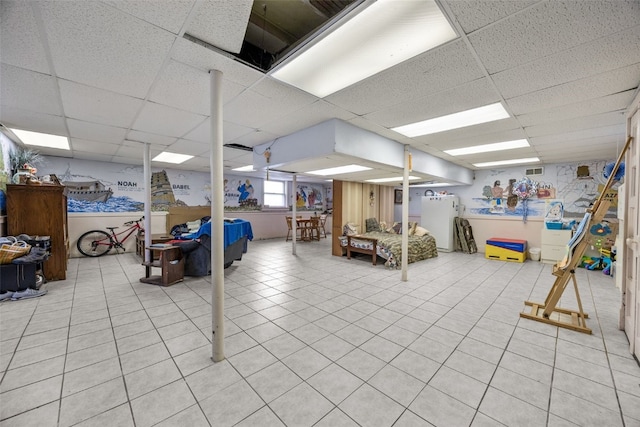 230 E Market St, Lisbon, IA 52253 - below grade area with visible vents, light tile patterned flooring, a paneled ceiling, and refrigerator