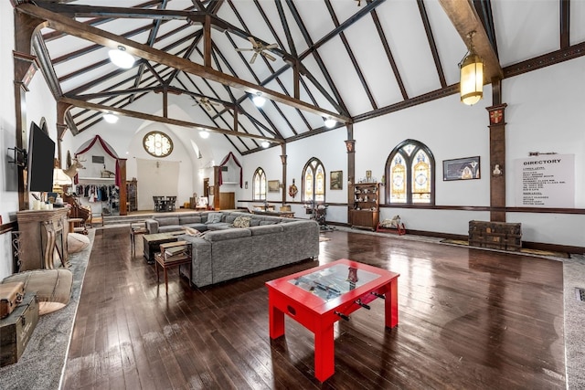 living room featuring high vaulted ceiling, ceiling fan with notable chandelier, ornate columns, and wood finished floors