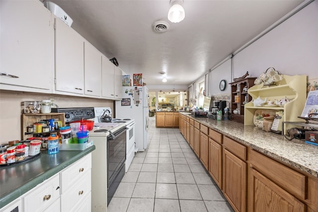 230 E Market St, Lisbon, IA 52253 - kitchen featuring visible vents, white cabinetry, electric stove, and light tile patterned flooring