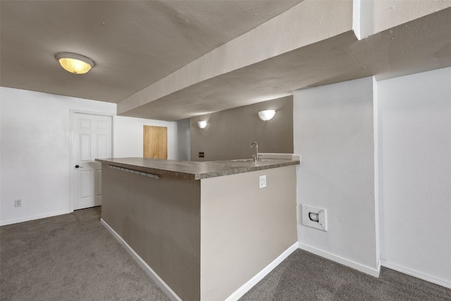 bar featuring a sink, dark carpet, and baseboards