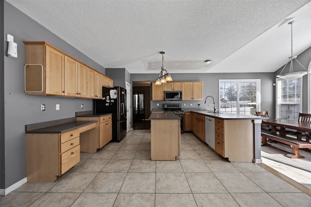 kitchen with a center island with sink, dark countertops, appliances with stainless steel finishes, pendant lighting, and a sink