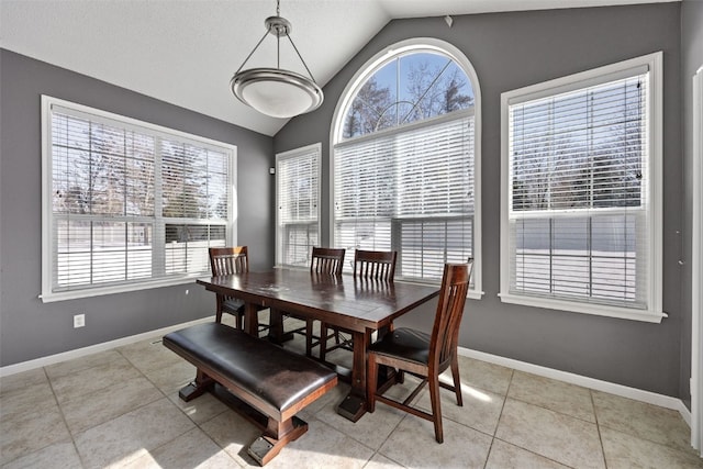 dining space with vaulted ceiling, a textured ceiling, light tile patterned flooring, and baseboards