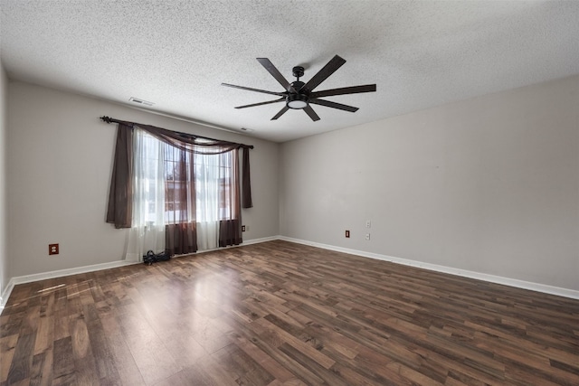 empty room featuring a ceiling fan, dark wood finished floors, a textured ceiling, and baseboards