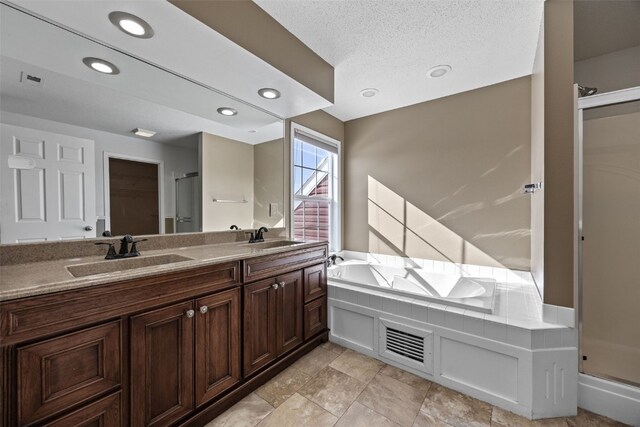 full bath with double vanity, a sink, a shower stall, and a bath