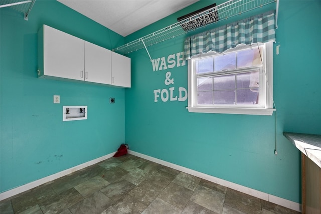 washroom with cabinet space, baseboards, stone finish floor, hookup for a washing machine, and electric dryer hookup