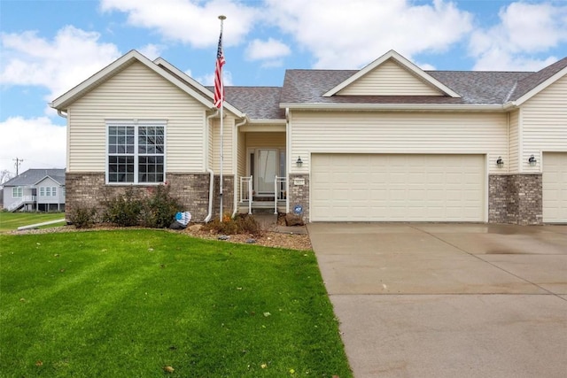 view of front of home featuring brick siding, roof with shingles, an attached garage, driveway, and a front lawn