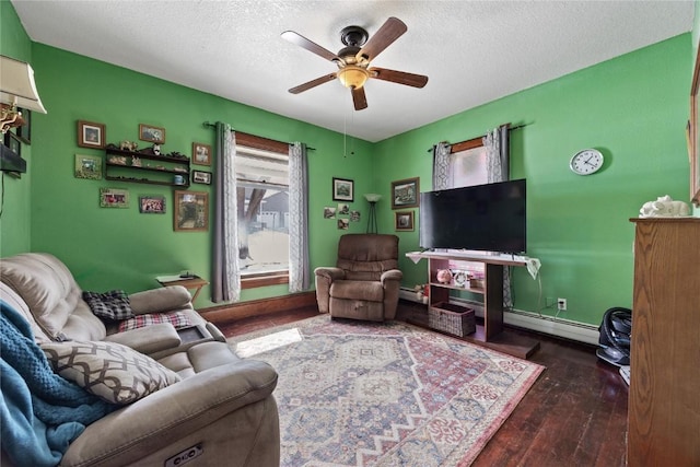 living area featuring ceiling fan, a baseboard heating unit, a textured ceiling, and dark wood-style floors