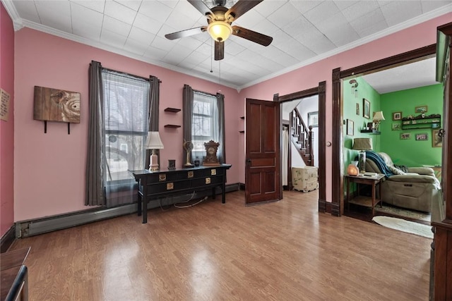 interior space featuring ceiling fan, stairway, crown molding, and light wood-style floors