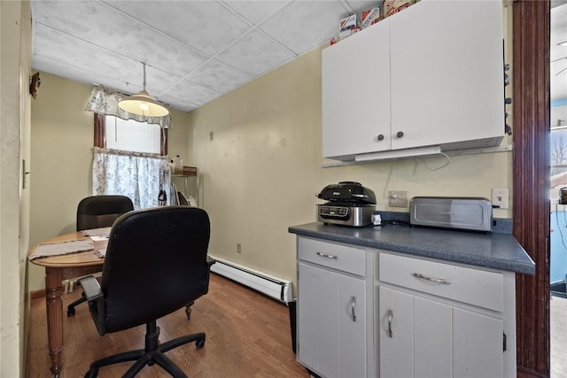 office area featuring a baseboard radiator and dark wood-type flooring