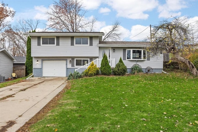 split level home featuring an attached garage, central AC, concrete driveway, and a front yard