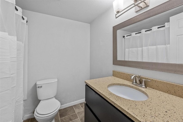 bathroom featuring toilet, tile patterned flooring, vanity, and baseboards