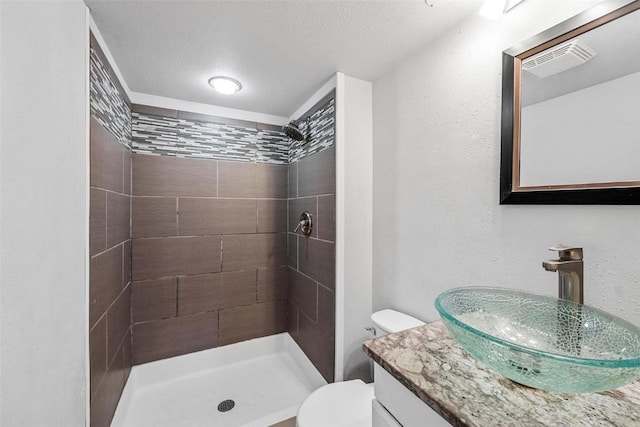 full bath with visible vents, toilet, a textured ceiling, vanity, and a shower stall