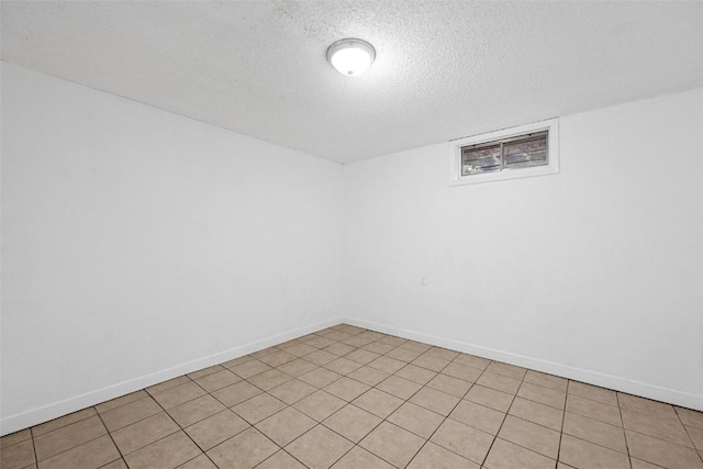 spare room featuring baseboards and a textured ceiling