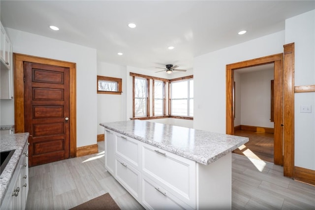 kitchen with recessed lighting, white cabinetry, and a center island