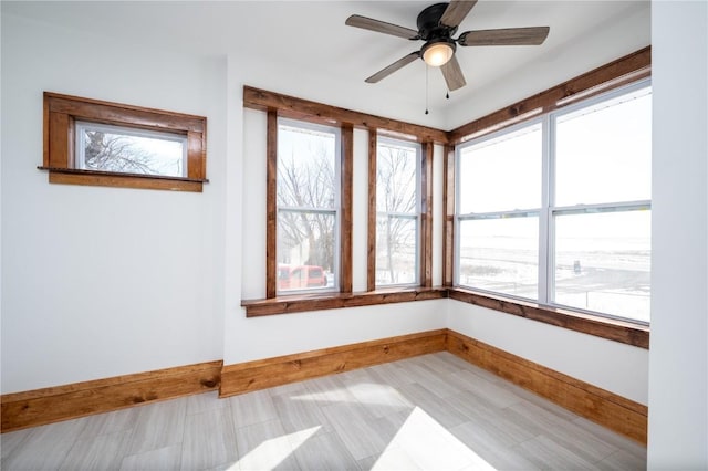 unfurnished sunroom with a ceiling fan