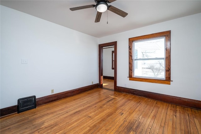 unfurnished room featuring ceiling fan, wood finished floors, visible vents, and baseboards