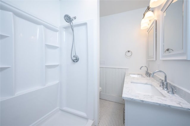 full bath with double vanity, walk in shower, a sink, and toilet