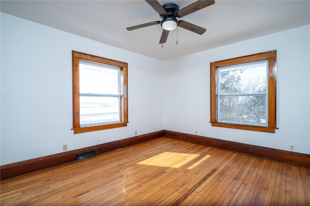 spare room with light wood-style floors, plenty of natural light, visible vents, and baseboards